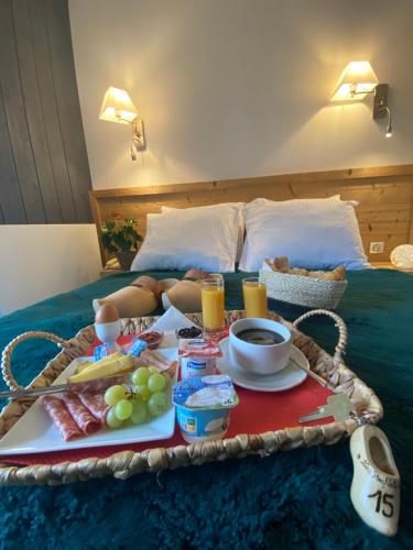 a breakfast tray with food on a bed at Les Reflets du Lac in Gérardmer