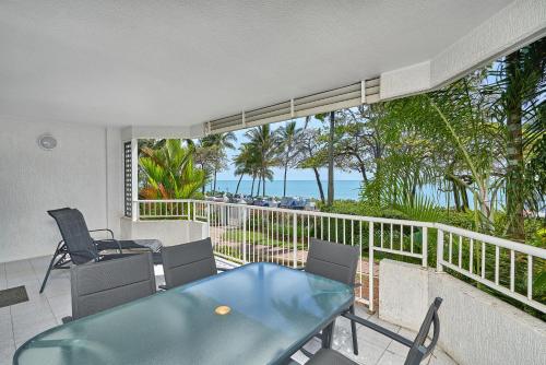 a dining room with a view of the ocean at Costa Royale Beachfront Apartment in Trinity Beach