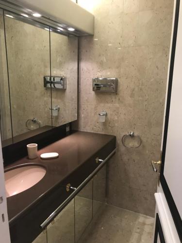 une salle de bain avec un lavabo et un miroir dans l'établissement Studio Gray d’Albion Cannes, à Cannes