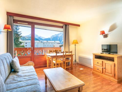 a living room with a couch and a table at Vacancéole - Résidence L'Edelweiss in Les Deux Alpes