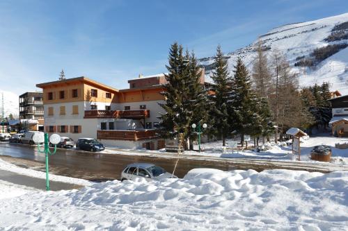una calle cubierta de nieve con un edificio en el fondo en Vacancéole - Résidence L'Edelweiss, en Les Deux Alpes