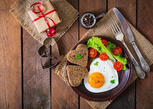 einen Teller Eier, Brot und Tomaten auf dem Tisch in der Unterkunft Guest house V gostyakh kak doma in Kasan