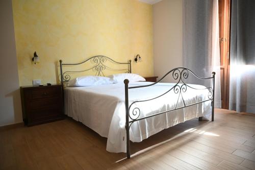 a bedroom with a white bed and a wooden floor at Arcobaleno dell'Etna in Calatabiano