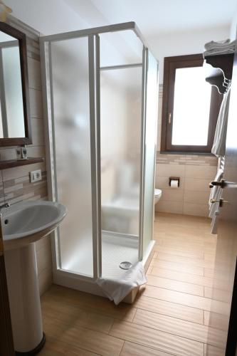 een badkamer met een glazen douche en een wastafel bij Arcobaleno dell'Etna in Calatabiano