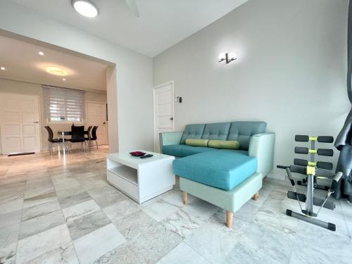 a living room with a blue couch and a table at Century Suria Aparment Langkawi by Zervin in Kuah