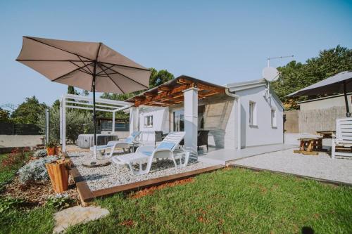 a patio with two chairs and an umbrella at Villa Molo in Novigrad Istria