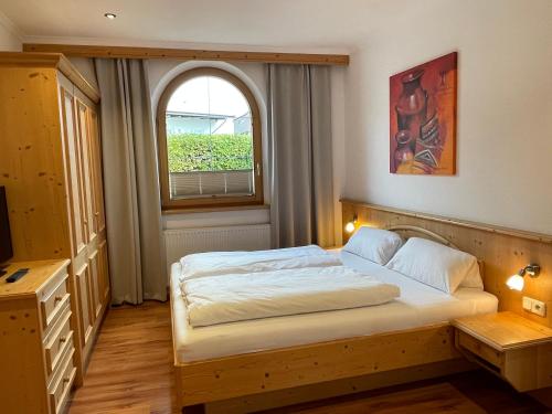 een slaapkamer met een bed en een raam bij Appartement Erler in Sankt Johann in Tirol