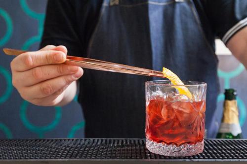 a person holding a stick in a drink at Trendy Hotel by Athens Prime Hotels in Athens