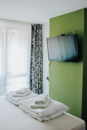 a room with three towels on a bed with a window at Вила Край реката in Botevgrad