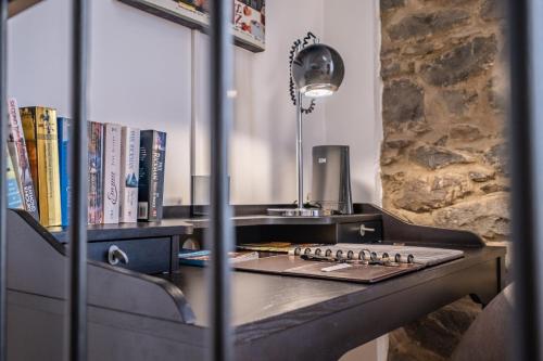 a desk with a lamp and books on it at Cayres Suites Carmo in Funchal