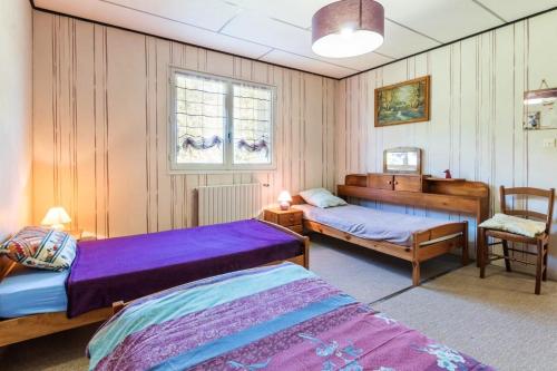 een slaapkamer met 2 bedden en een stoel bij Maison de 2 chambres avec jardin amenage et wifi a Champagney in Champagney