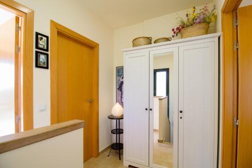 a hallway with a white cabinet with a mirror at Casa Falset in L'Estartit