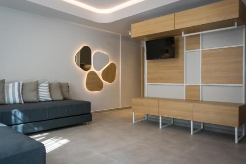 a living room with a couch and a tv at Evdokia Suites in Gouves