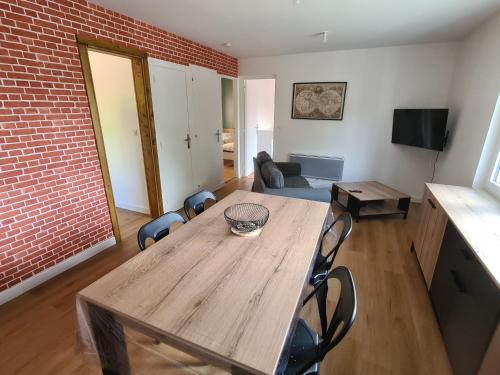 een woonkamer met een houten tafel en stoelen bij Le calme de la nature à 8 minutes des plages in Sémussac