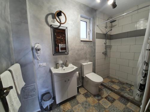a bathroom with a white toilet and a sink at Edith's House in Turda