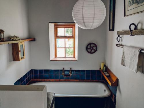 a bathroom with a bath tub and a window at The Cottage in Prince Albert