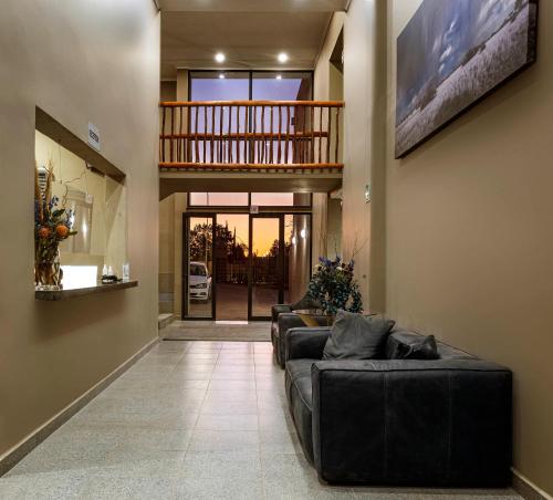 a large living room with couches and a staircase at Upington Inn in Upington