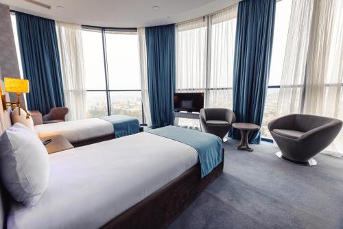 a hotel room with two beds and a chair at Meta Business Hotel By King David in Tbilisi City