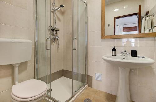a bathroom with a shower and a toilet and a sink at Enchanted Villa in Tavira
