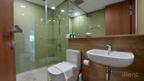 a bathroom with a toilet and a sink and a shower at Sky Suites with KLCC Twin Tower View by iRent365 in Kuala Lumpur