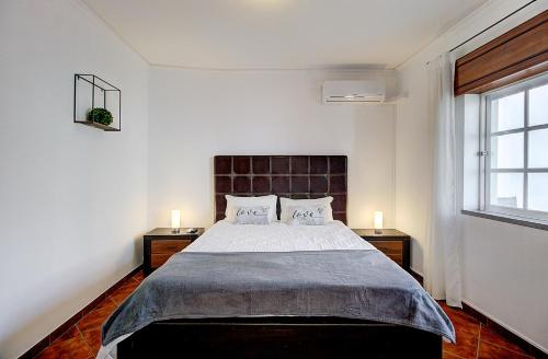a bedroom with a large bed with two night stands at Enchanted Villa in Tavira