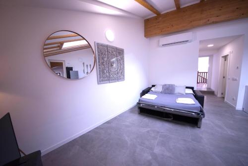 una camera da letto con un letto e uno specchio a parete di Best Location a Riva del Garda