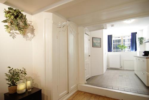 a hallway with white walls and a door with a window at Cosy apartment right in the city center with AIRCO! in Amsterdam