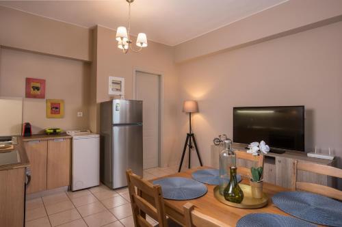 a kitchen and dining room with a table and a refrigerator at Tholos Apartments in Chania Town