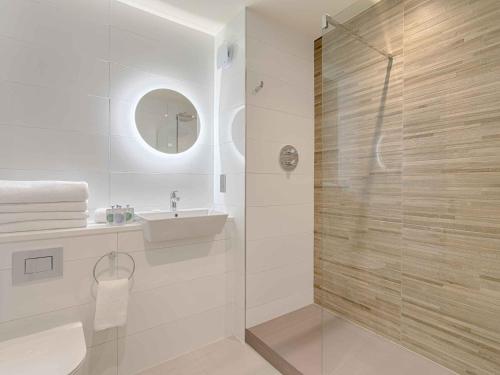 een badkamer met een glazen douche en een wastafel bij The Mariner, Westport in Westport