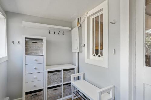 a dressing room with white cabinets and a stool at 128 Spruce Street home 