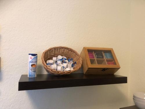 a bathroom shelf with a basket and a box of toothpaste at Pension Hansehof in Salzwedel