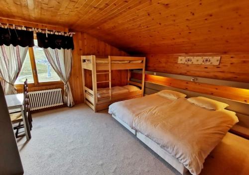 a bedroom with a bed in a wooden cabin at Hotel Télécabine in Les Crosets