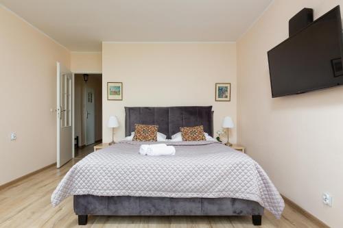 a white bedroom with a large bed with a gray headboard at Royal Park Apartments Warsaw Sielecka by Renters in Warsaw