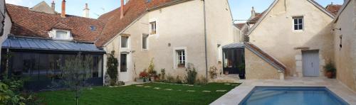 a house with a swimming pool in the yard at La Croix au Maitre in Coulanges-la-Vineuse