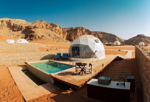 a dome tent in the desert with a swimming pool at Moon Retreat in Sharjah