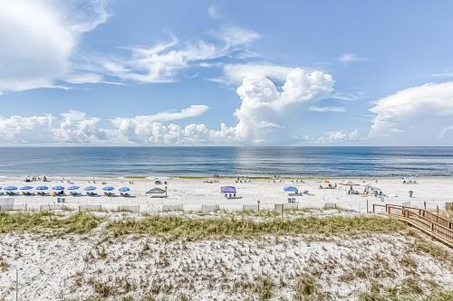 a beach with chairs and umbrellas and the ocean at The Edgewater 44 in Gulf Shores