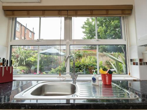 a kitchen sink with a large window above it at The Georgian Cottage in Bedale