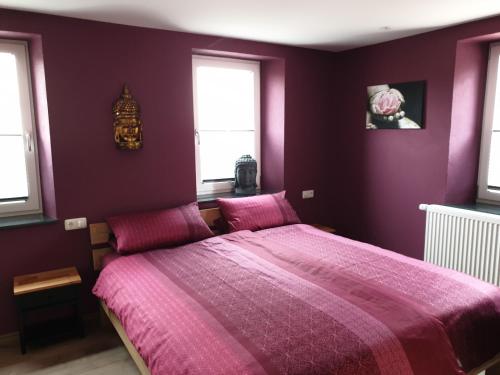 a purple bedroom with a bed with purple sheets and windows at Schlafwelt - Thailand in Elsenfeld