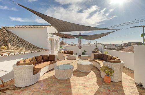 a patio with couches and tables on a roof at Enchanted Villa in Tavira