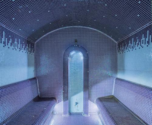 a white bathroom with a shower and a tub at Kristály Hotel in Keszthely