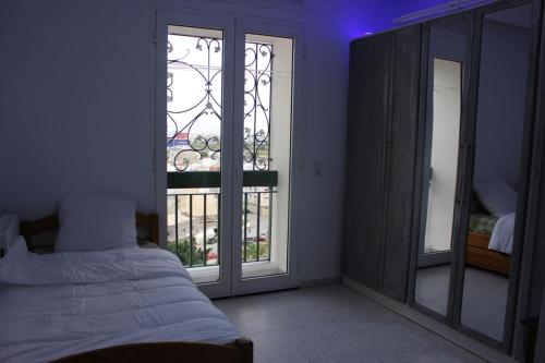 a bedroom with a bed and a glass door at Appartement Alain savary in Tunis