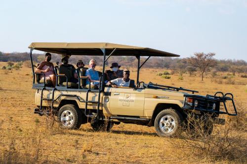 a group of people riding in a jeep at Honeyguide Ranger Camp in Golders Green
