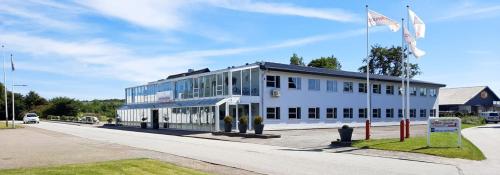 a large white building with a flag in front of it at Dolphin Hotel Herning in Herning