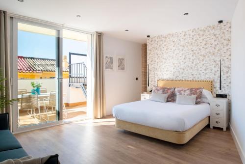 ein Schlafzimmer mit einem großen Bett und einem Balkon in der Unterkunft Hommyhome Conteros Cathedral Apartments in Sevilla