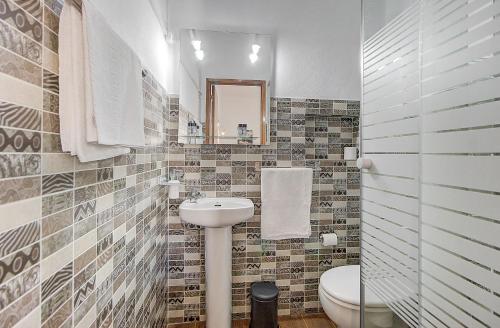 a bathroom with a sink and a toilet and a mirror at Lagoas in Tavira