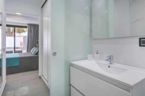 a white bathroom with a sink and a shower at Two Dreams Luxury Villa in Corralejo