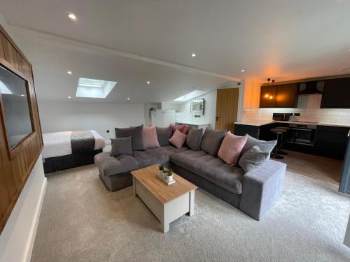a living room with a couch and a table and a bed at Woodroyd apartments in Luddenden Foot