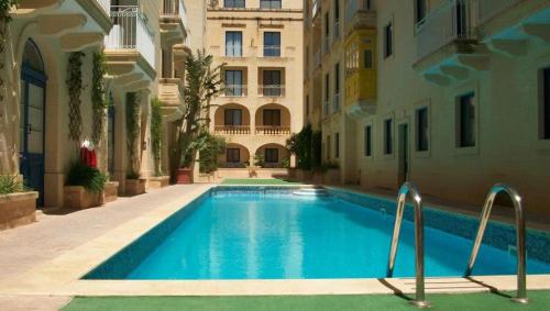 a swimming pool in the middle of a building at Ir-Rixa Holiday Penthouse in Għajnsielem