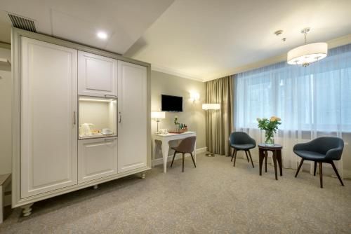 um quarto de hotel com uma mesa e cadeiras e uma secretária em Ratonda Centrum Hotels em Vilnius