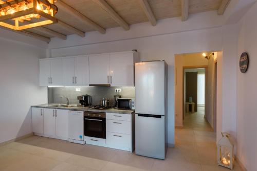 a kitchen with white cabinets and a refrigerator at Cycladic Breeze Villas in Kampos Paros